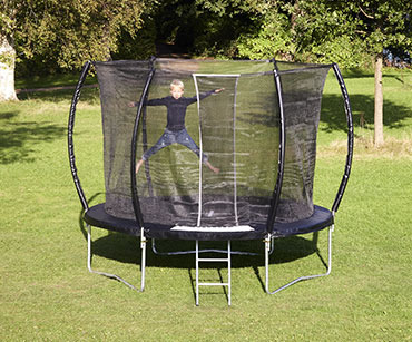 Musta trampoliini kesäisellä nurmella