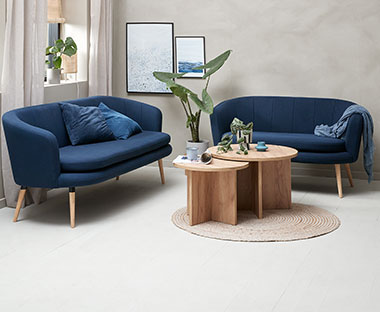 Siniset sohvat ja tammenväriset tyylikkäät sohvapöydät olohuoneessa