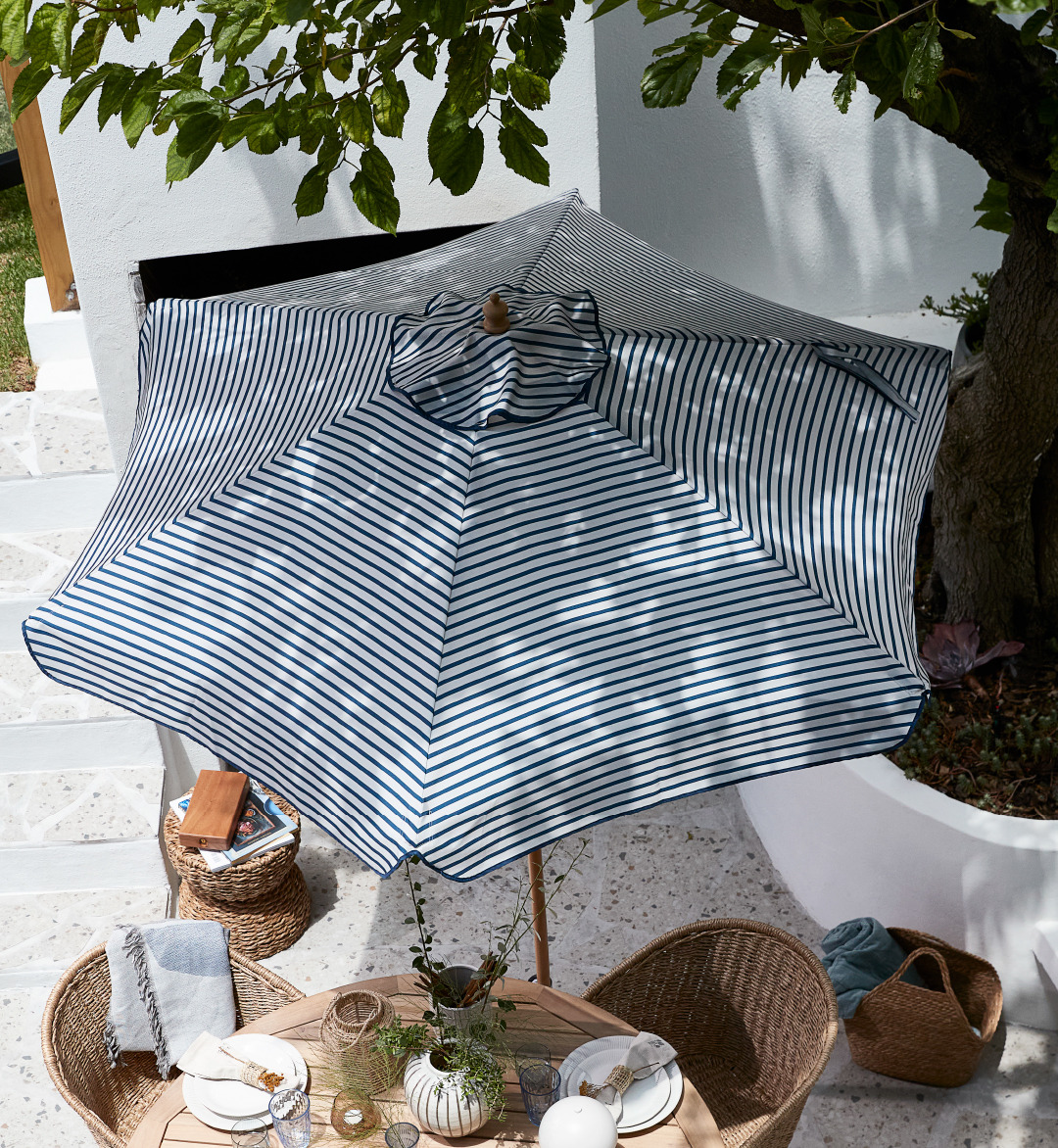 Siniraidallinen aurinkovarjo terassilla