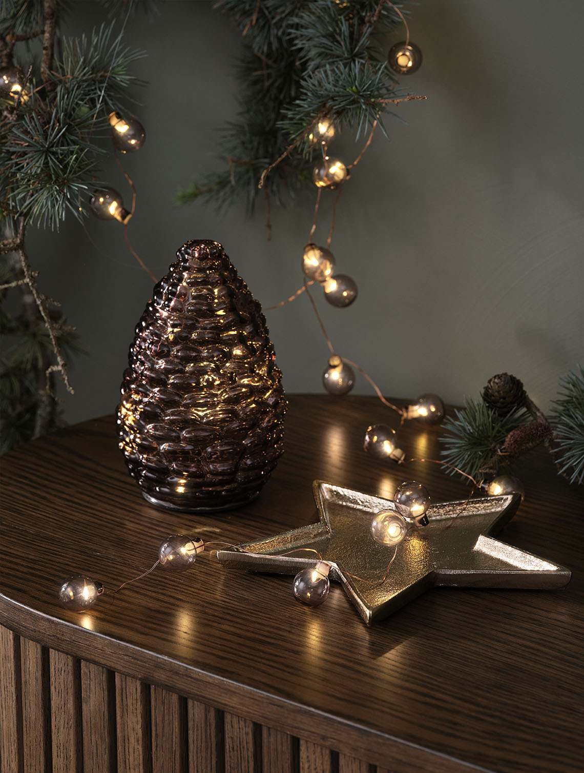 DELLING joulukäpy ja ALV valoketju Koristeellisia jouluvaloja, kuten lasikäpy ja kullansävyinen joulupallovaloketju senkin päällä
