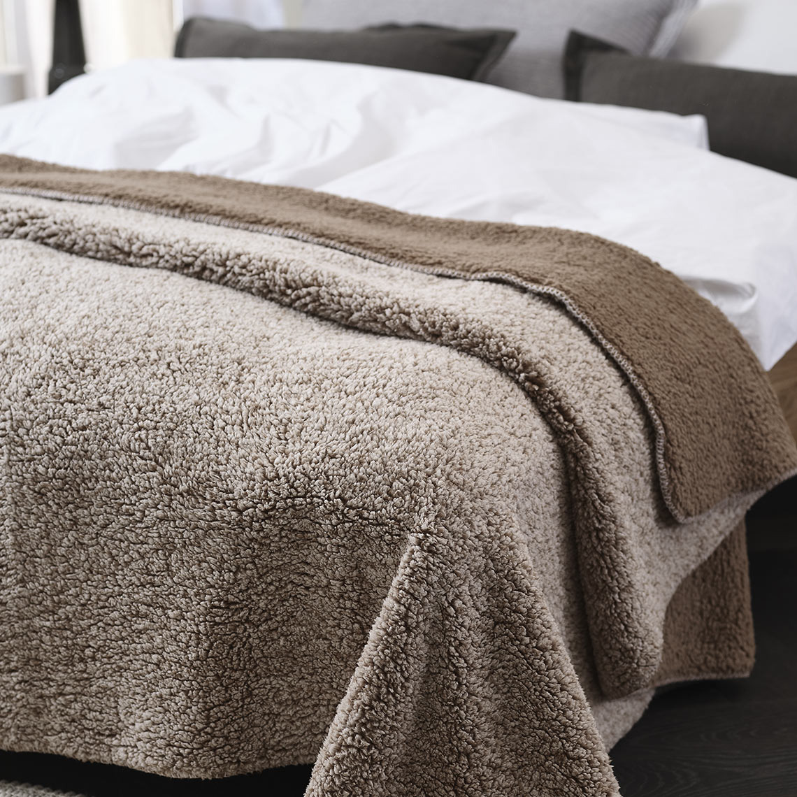 Ruskea fleecetorkkupeitto sängyllä makuuhuoneessa