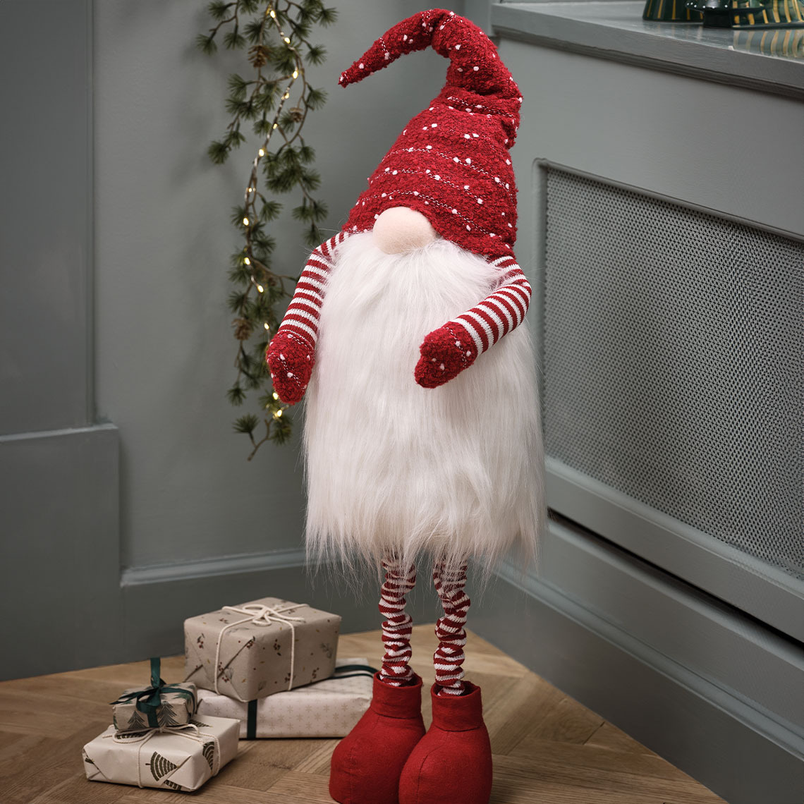 Pitkä joulutonttu, jolla on punainen tonttulakki ja iso parta