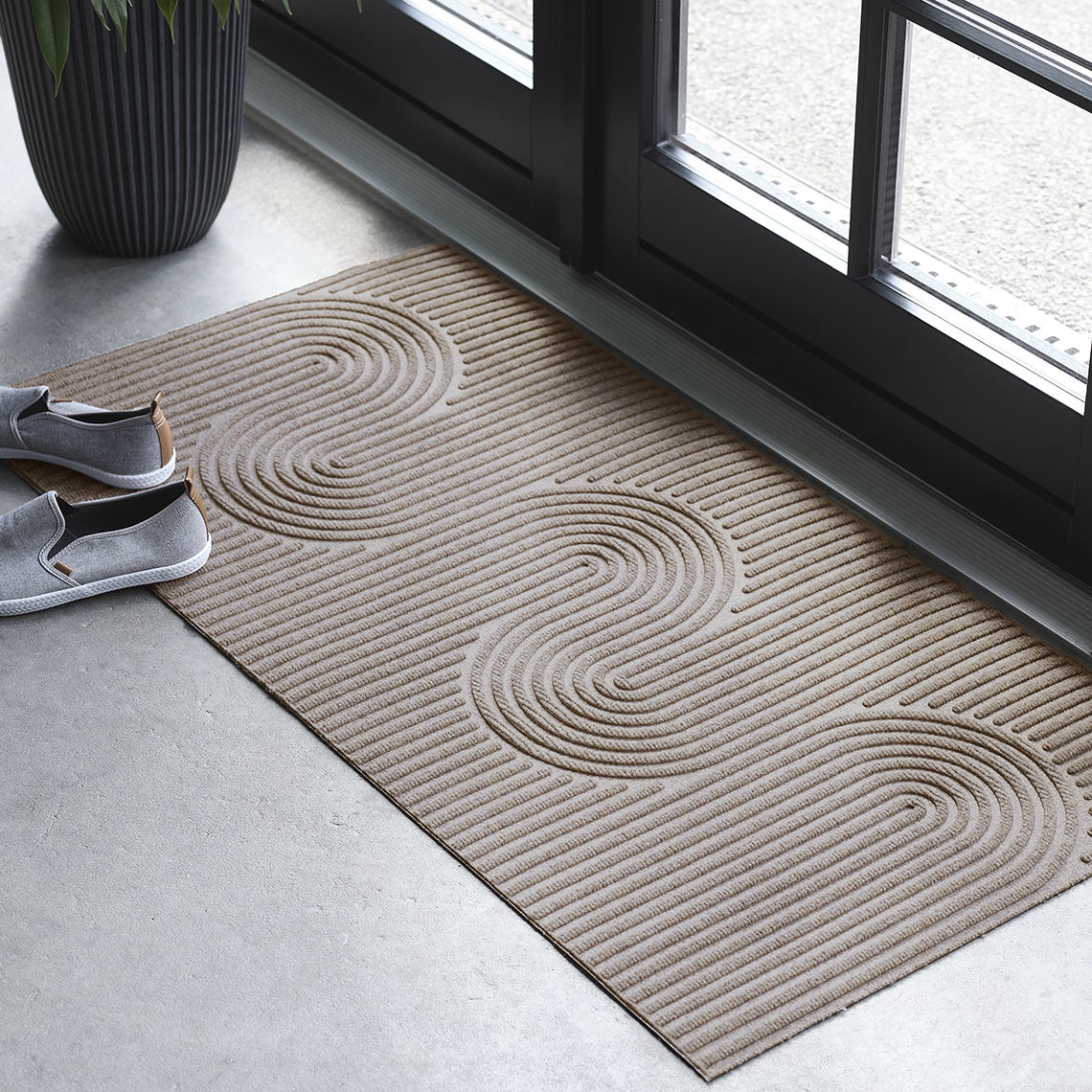 Neliönmuotoinen sisä-/ulkokäyttöön tarkoitettu kynnysmatto sisäänkäynnin oven edessä