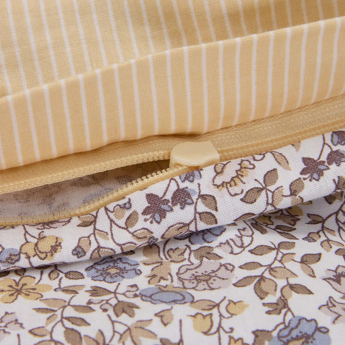 Puuvillainen vuodevaate, jossa on pieniä pastellivärisiä kukkasia lilan ja keltaisen sävyissä