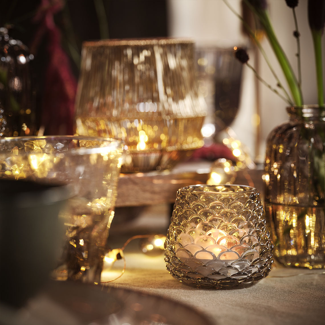 BIFROST tuikkukippo Kynttilöiden ja tuikkukipoissa olevien tuikkujen sekä valoketjujen valaisema ruokapöytä