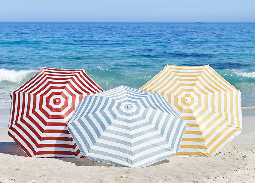 Three large parasols on a beach 