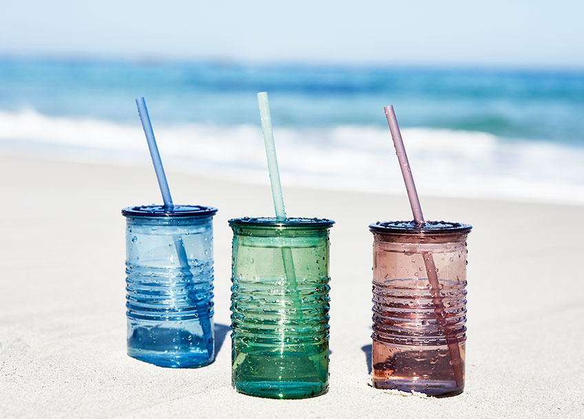 ALF drinking cups available in blue, green and red Three drinking cups in different colours in the sand on a beach