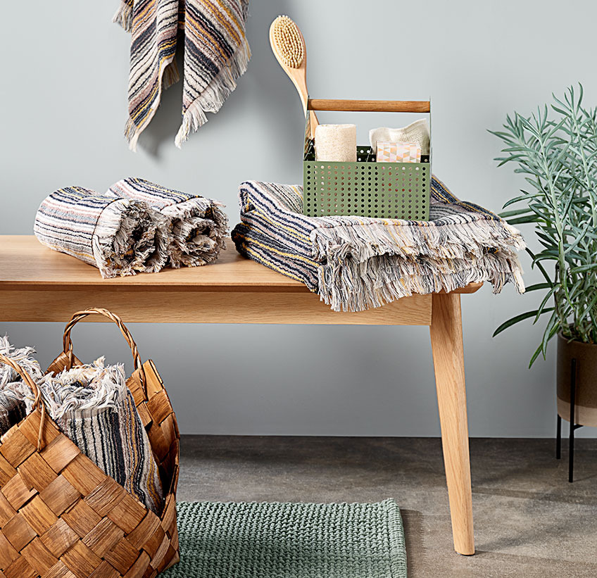 SEGERSTA towels in different sizes, VICKLEBY storage box with VALJE bath brush on KALBY bench Cotton towels and other bathroom accessories on a bench
