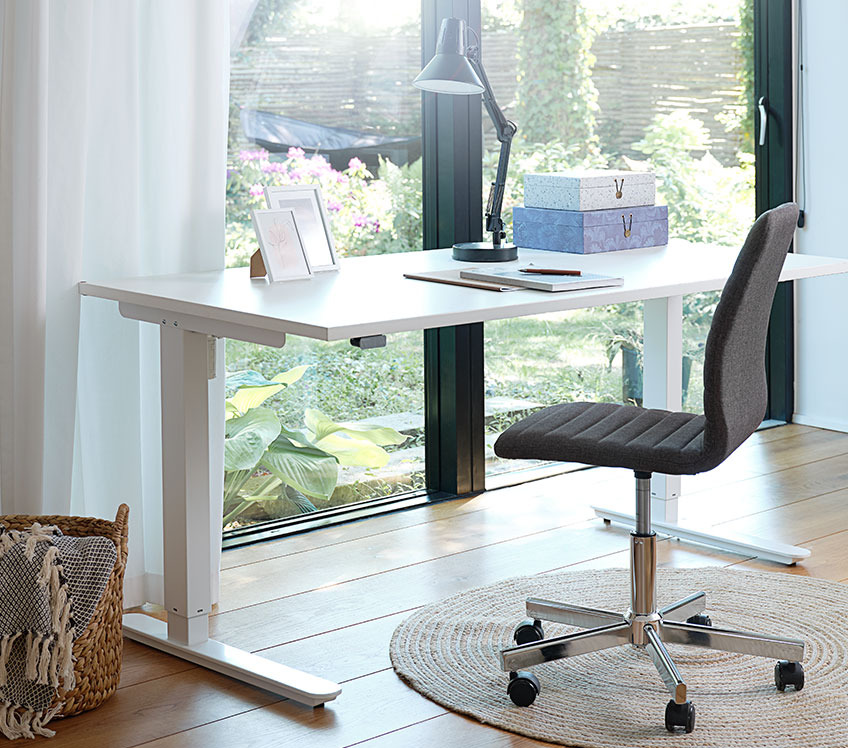 Fabric office chair at an adjustable office desk by a window