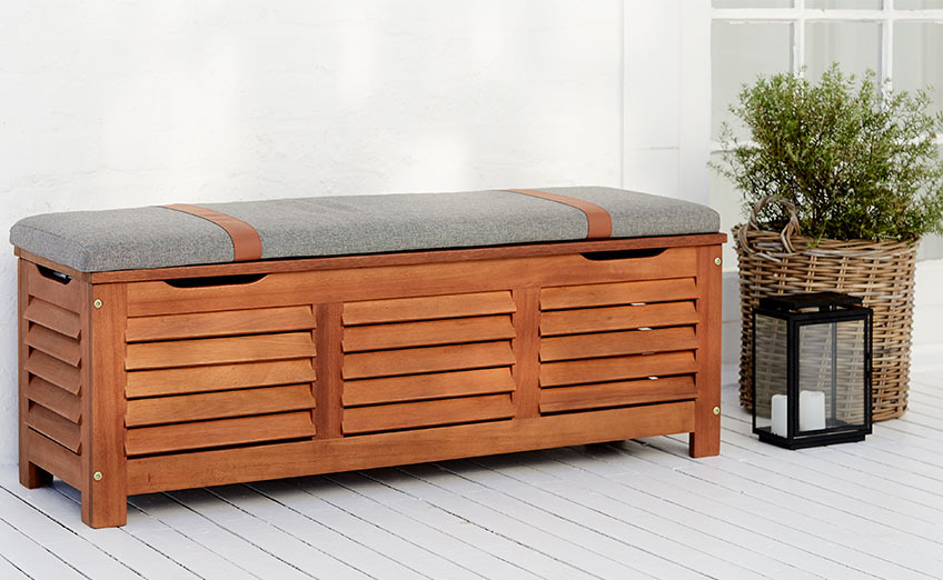 KARLBY garden bench with storage space and seating Wooden outdoor storage bench on a patio with planter and lantern