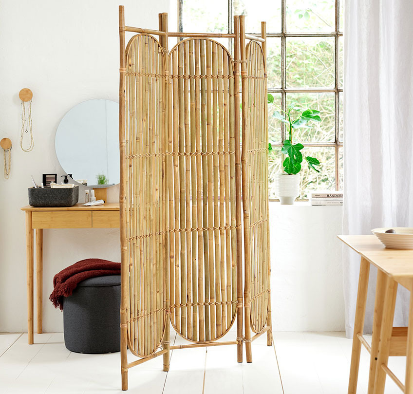 Bamboo dressing screen serves as a room divider between a dining section and a sleeping section