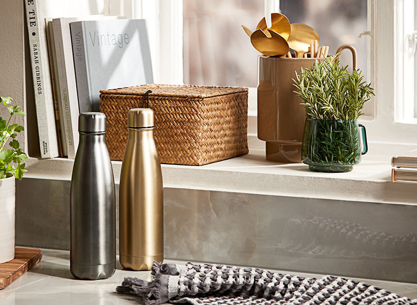 Thermal drinking bottles, storage box and storage jar with salad servers in a kitchen 