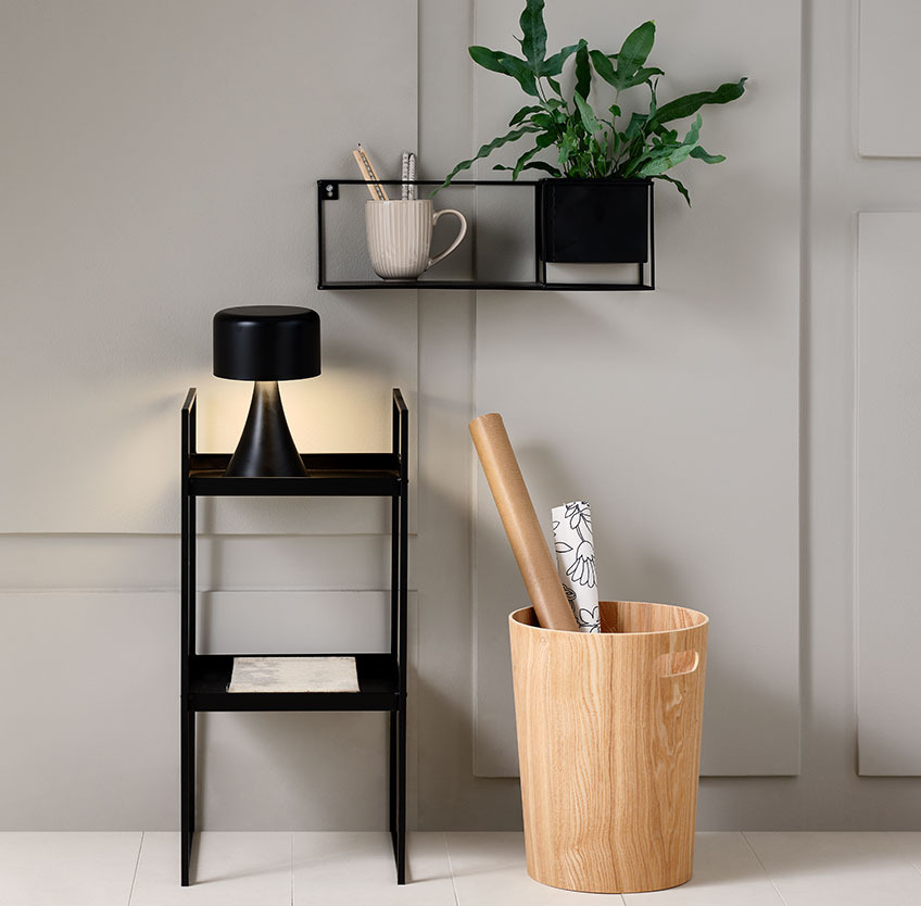 ALBIN basket below VILMER shelf with plant pot Wooden basket on the floor below a black shelf with a plant pot