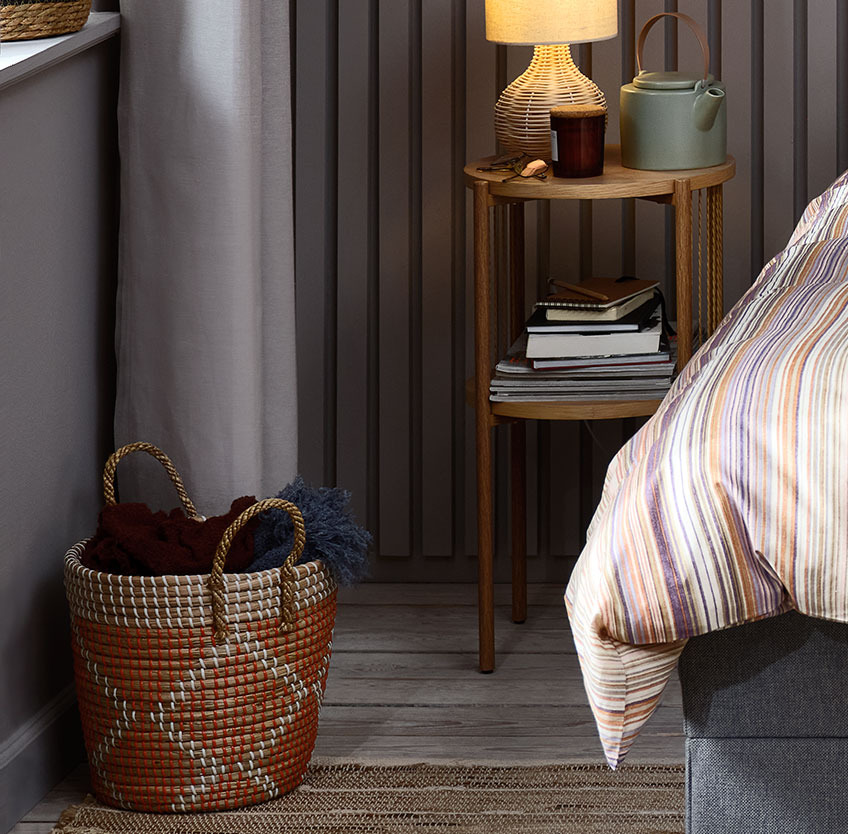CHRISTER seagrass basket with a geometric pattern Round basket on the floor in a bedroom