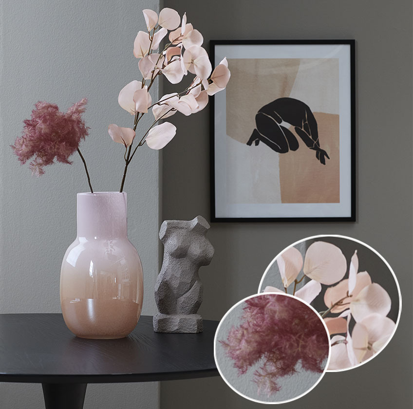 Vase with artificial flowers and a sculpture of female body on a table 