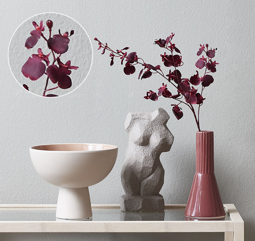 Small vase with artificial orchid flower and sculpture of a female body