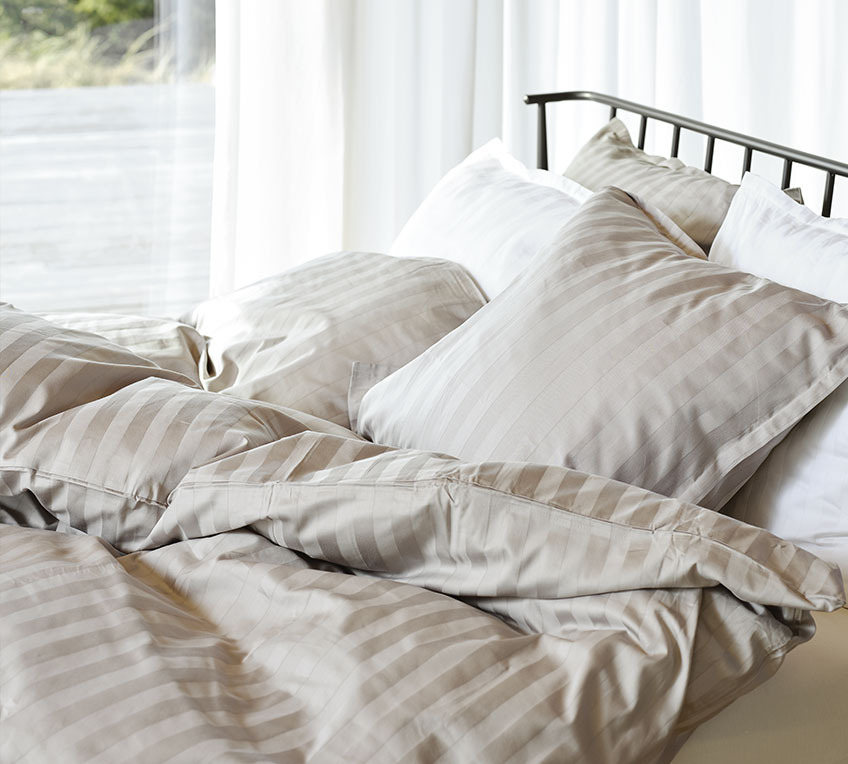 NELL-pussilakanasetti Bed with duvets and pillows with a striped bedding