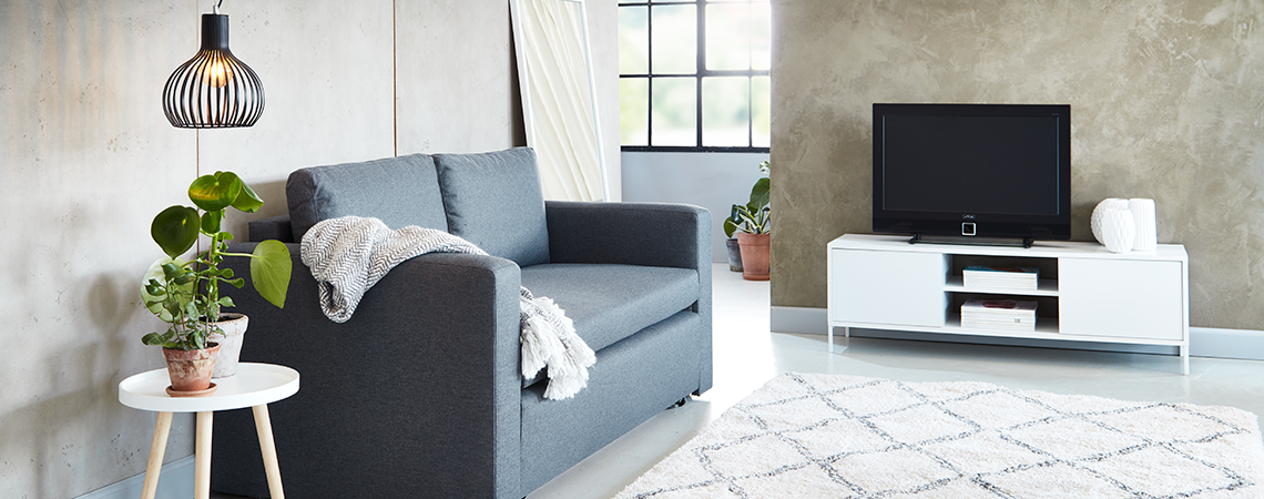Valkoinen TV-taso ja sohva